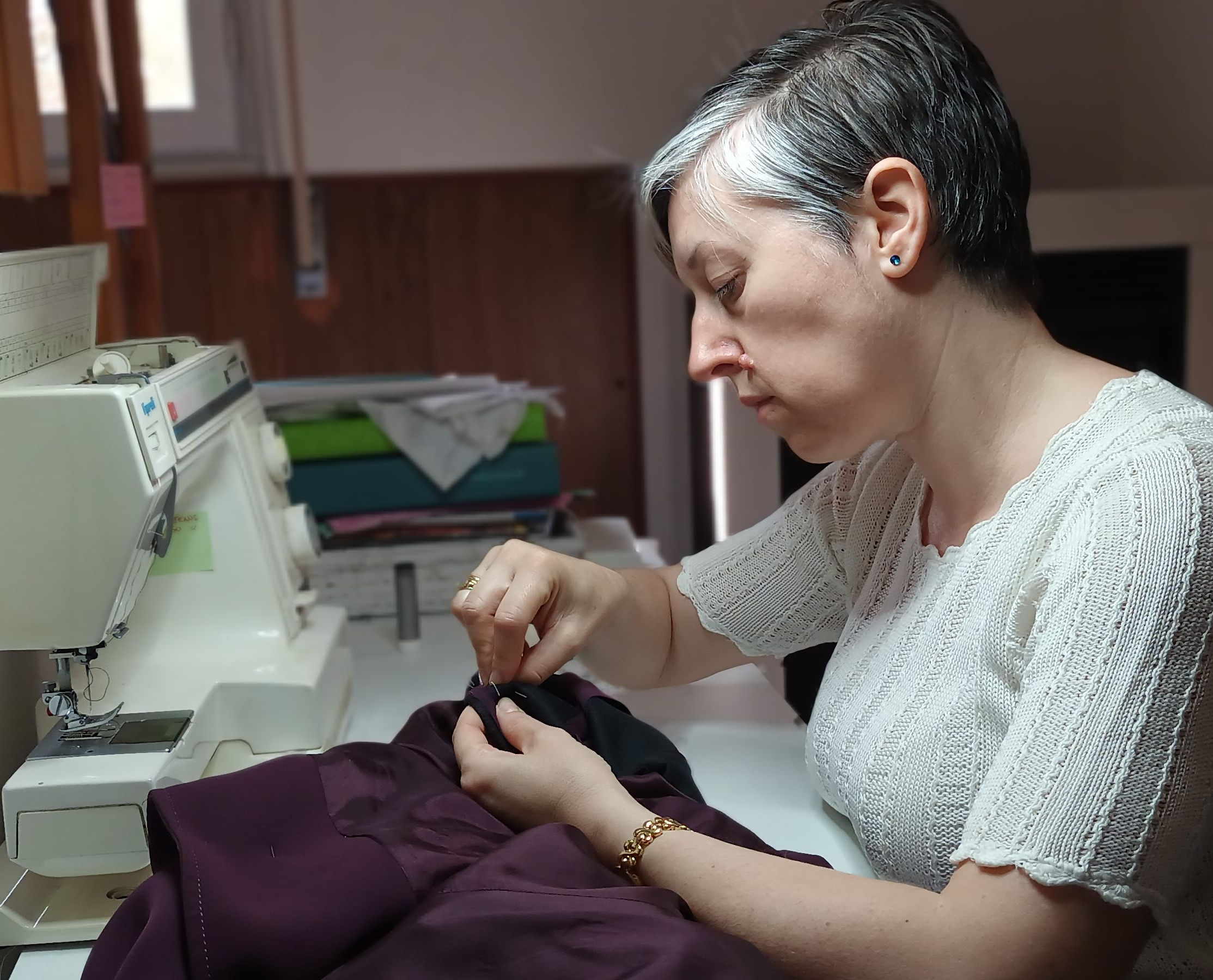 Maurizia mentre lavora a una macchina da cucito,